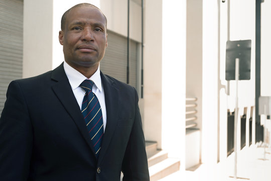 Black businessman in a suit loking successfull in an urban background