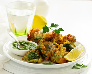 Fried broccoli in batter with green sauce. Selective focus
