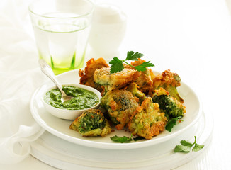 Fried broccoli in batter with green sauce. Selective focus