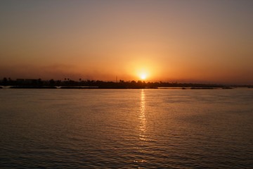 Naklejka premium Sunset viewed from across a river