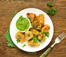 Fried broccoli in batter with green sauce. Selective focus