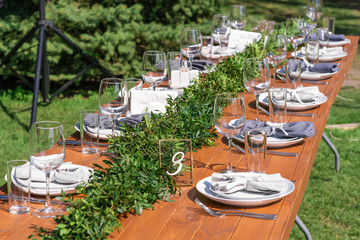 Preparing for an open-air party. Decorated with fresh flowers served tables. Table number. Decoration Details