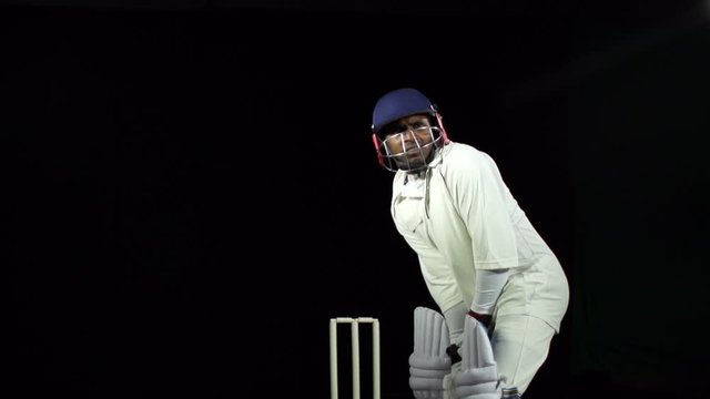 Asian Cricket Batsman hitting the ball - Cut shot. Black background. In white 