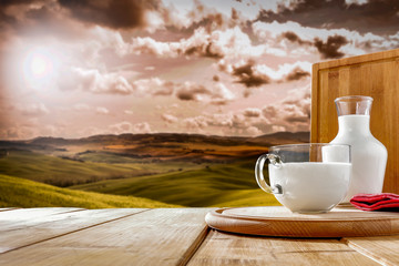 Fresh milk on wooden board and landscape of Tuscany 