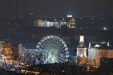 Aerial night light landscape of Square of Contracts (Contract Square) with Ferris wheel. Famous touristic place and romantic travel destination. Podil district, Kyiv, Ukraine