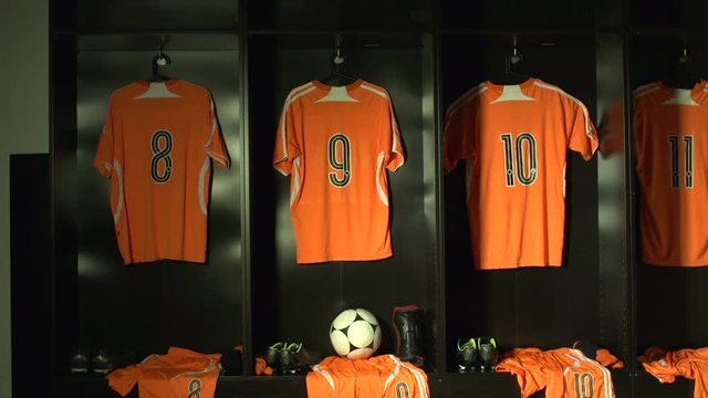 Soccer /  Football Changing room / Locker room. All the kit or uniform is laid out ready for the players. Tracking Shot Towards