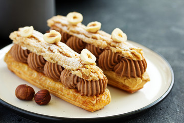 Homemade eclair with chocolate and nuts. Pastry.
