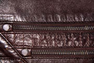 Two zippers on brown leather