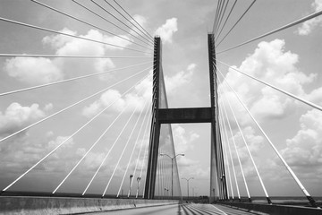 Low Angle View Of Suspension Bridge Against Cloudy Sky