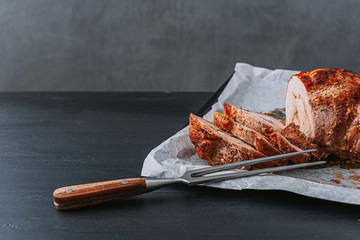 meat baked on a baking sheet and parchment paper next to a meat fork