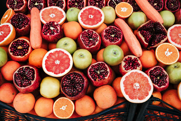 A bunch of fruit cut Pomegranates, Oranges, Grapefruitst and Carrot. Street food snack and production of fresh juice.