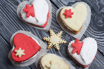 Marshmallow sandwiches decorated with cookies in the shape of a snowflake. On brushed pine boards painted in black and white.