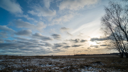 Obraz premium Beautiful setting sun over frozen field