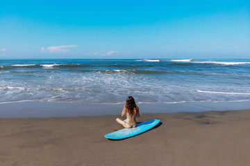 beautiful sporty surfing woman in sexy bikini sit on longboard surf surfboard board on beach before surfing. Modern active sport lifestyle and summer vacation