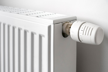 Close-up of thermostatic radiator valve / TVR fitted to household hot water heating system radiator to control the temperature of a room - obrazy, fototapety, plakaty
