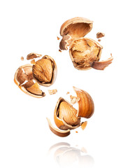 Group of crushed hazelnuts in the air close-up on a white background