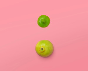 sliced yellow green lemon lime on a pink background