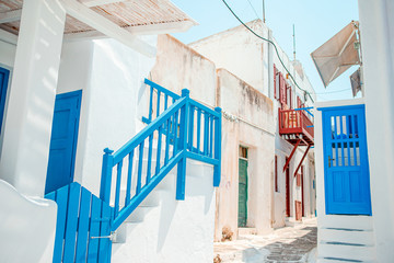 Naklejka premium The narrow streets of the island with blue balconies, stairs and flowers.