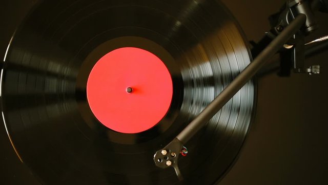 Close up of turntable tonearm playing vinyl record