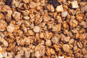 Useful and tasty muesli with nuts, rasins and flakes. Selective focus macro shot with very shallow depth of field. Healthy and vegetarian lifestyle