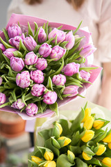Two Beautiful bouquets of tulips in womans hands. the work of the florist at a flower shop. Delivery fresh cut flower. European floral shop.
