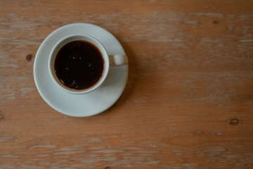 White Coffee Cup filled with Espresso on wooden table . table Top view.