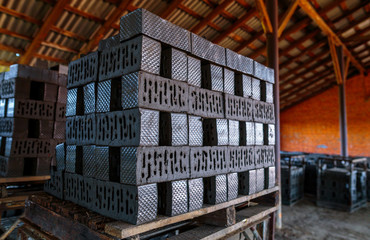 Production of clay bricks at a brick factory. Molded bricks stacked on pallets are dried before...