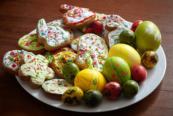 Composition of painted Easter eggs and cookies on a plate