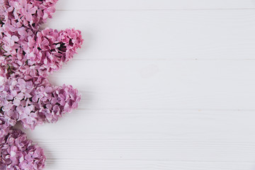 Floral pattern of a branch of lilac on a wooden white background. Top view. Flat lay. Spring concept. Copy space