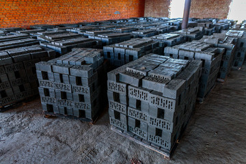 Production of clay bricks at a brick factory. Molded bricks stacked on pallets are dried before...