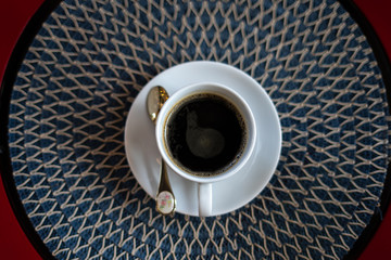  A beautiful cup of coffee with spoon and saucer on a pattern table in the morning. top view. and...
