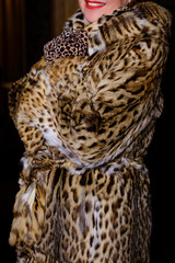 Smile of woman wearing trendy animal, leopard print faux fur coat