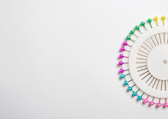 set of colored needles in the shape of a sun against a white background. sewing and knitting concept