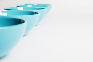 bright blue dishes in a row on a white background close up. nice clean bowl for soup