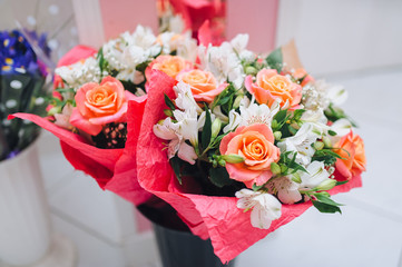 Beautiful luxury bouquet of mixed flowers in vase. Orange, roses. eustoma in red paper. The concept of celebrating Valentine's Day, March 8 and birthday.