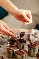 Fototapeta na wymiar Young girl tasting delicious dark chocolate fondant cakes. Served in vintage ladles. Delicious elegant dessert for sweet-tooth, sweet breakfast. Romantic atmosphere, aromatherapy. Close up, macro
