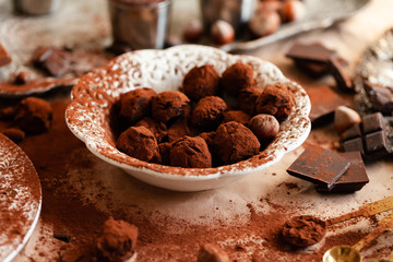 Homemade delicious dark chocolate  truffles. Served in white vintage plate, sprinkled with cocoa powder. Delicious elegant dessert for sweet-tooth. Romantic atmosphere. Close up, macro