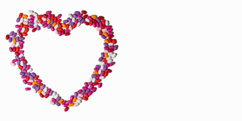 heart of colored pills on a white background. colored pills isolatred on white. empty space for text