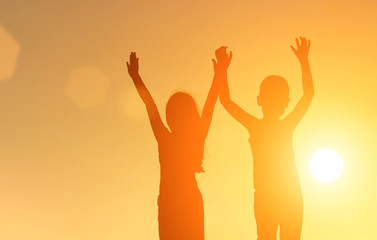 silhouette of children on a sunset background. friendship concept