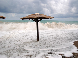 beach umbrellas against the sea in a strong storm. swimming is prohibited and spoiled vacation due...