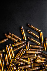 Background from empty cartridges for rifles and carbines. Shiny brass shells scattered on the surface.