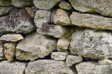 Stone wall of shell rock, lightly covered with moss, folded by hand.