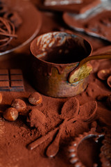 Delicious homemade chocolate preparation process. All kitchen tableware covered with cocoa powder. Intense brown color, aromatherapy. Dark and moody, macro, top view