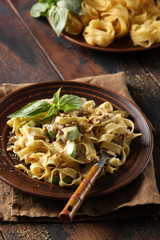 The concept of Italian cuisine. Pasta with zucchini and cheese on an old wooden background