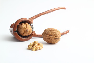 Walnuts with nutcracker isolated on white background
