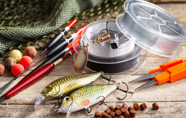 Fishing rods and spinnings in the composition with accessories for fishing on the old background on...