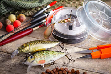 Fishing rods and spinnings in the composition with accessories for fishing on the old background on...