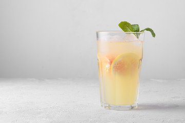 Summer refreshing lemonade with mint on a light background. A glass of citrus cocktail in a light key. Close up. Summer Vitamin cocktail of orange, lemon and grapefruit.