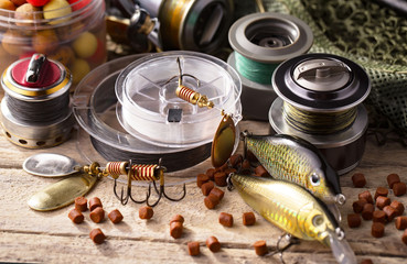 Fishing rods and spinnings in the composition with accessories for fishing on the old background on...