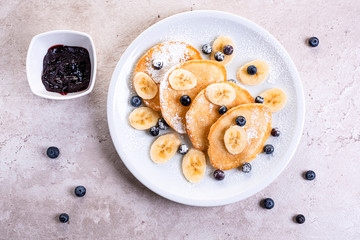 pancakes with banana and blueberries on a white plate, tasty and beautiful